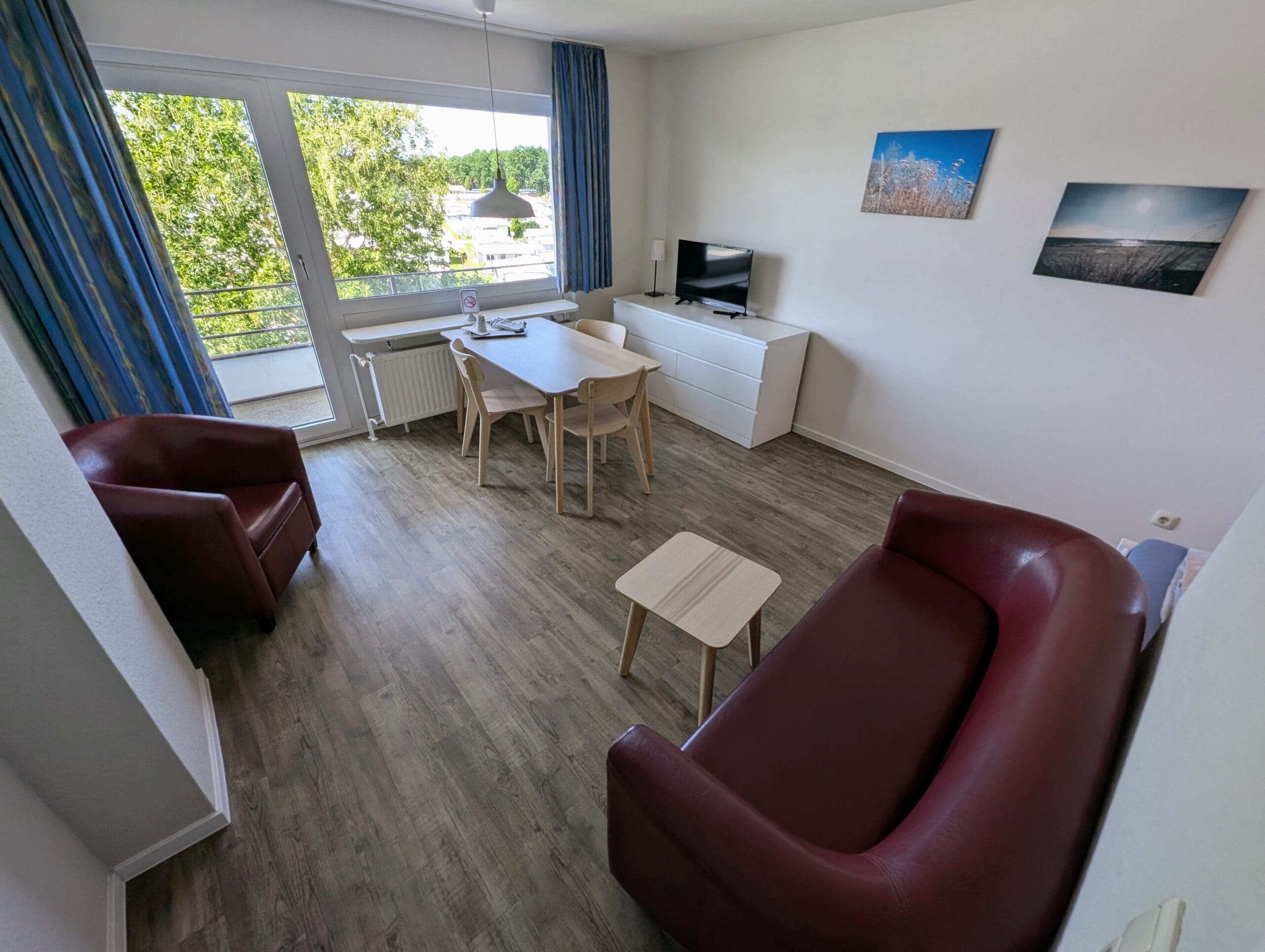Wohnbereich mit Tisch, Sofa und Fernseher