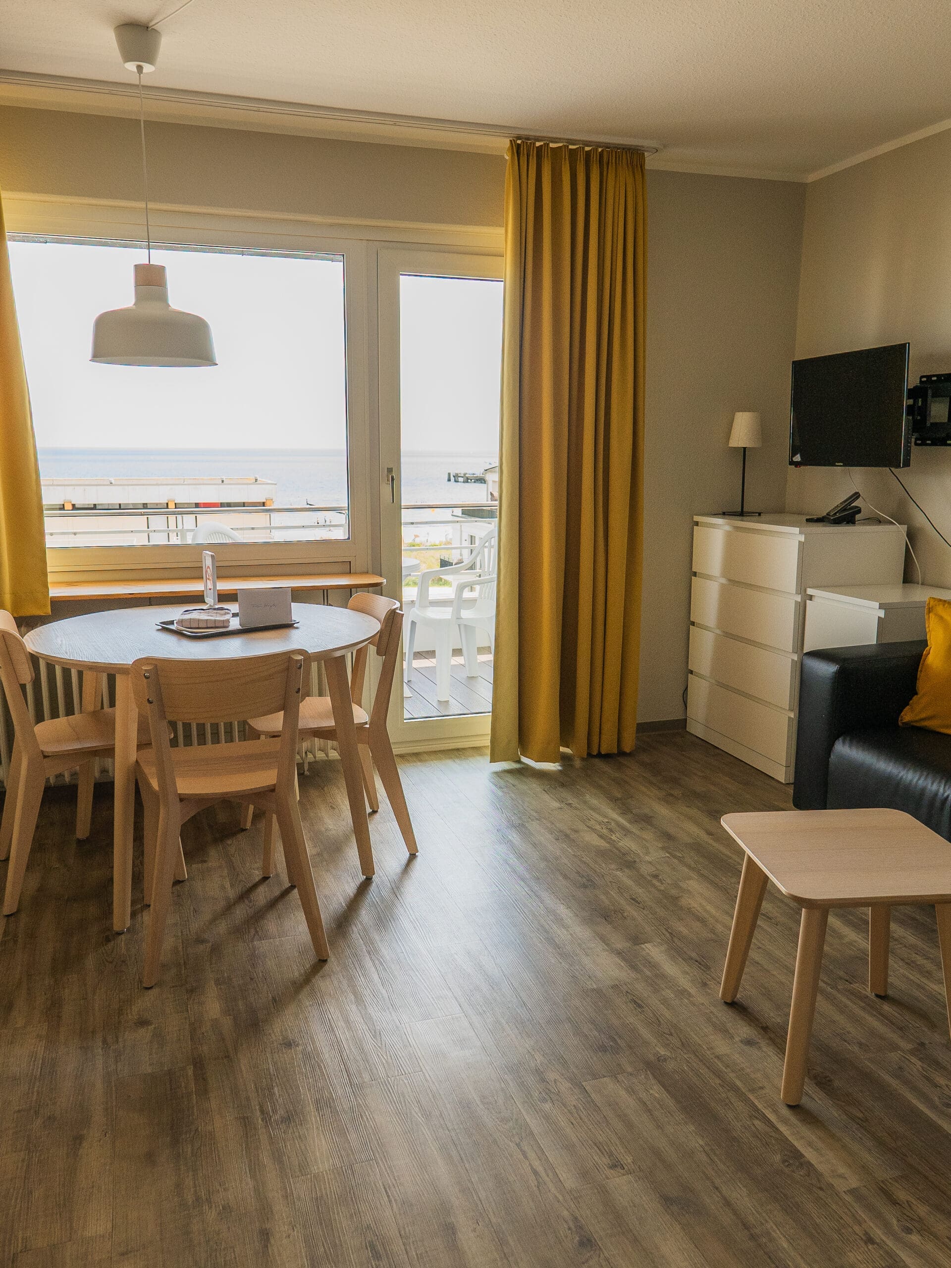 Zimmer mit Esstisch, Fenster und Vorhängen