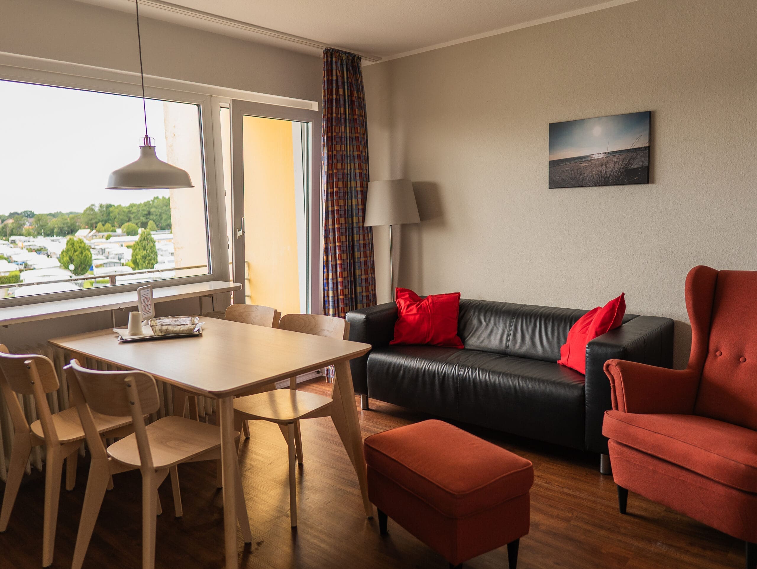 Wohnzimmer mit Sofa, Esstisch und Fenster